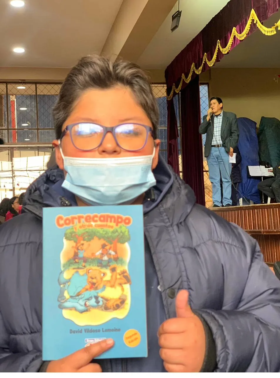 Young reader with David Vildoso's children's book Correcampo