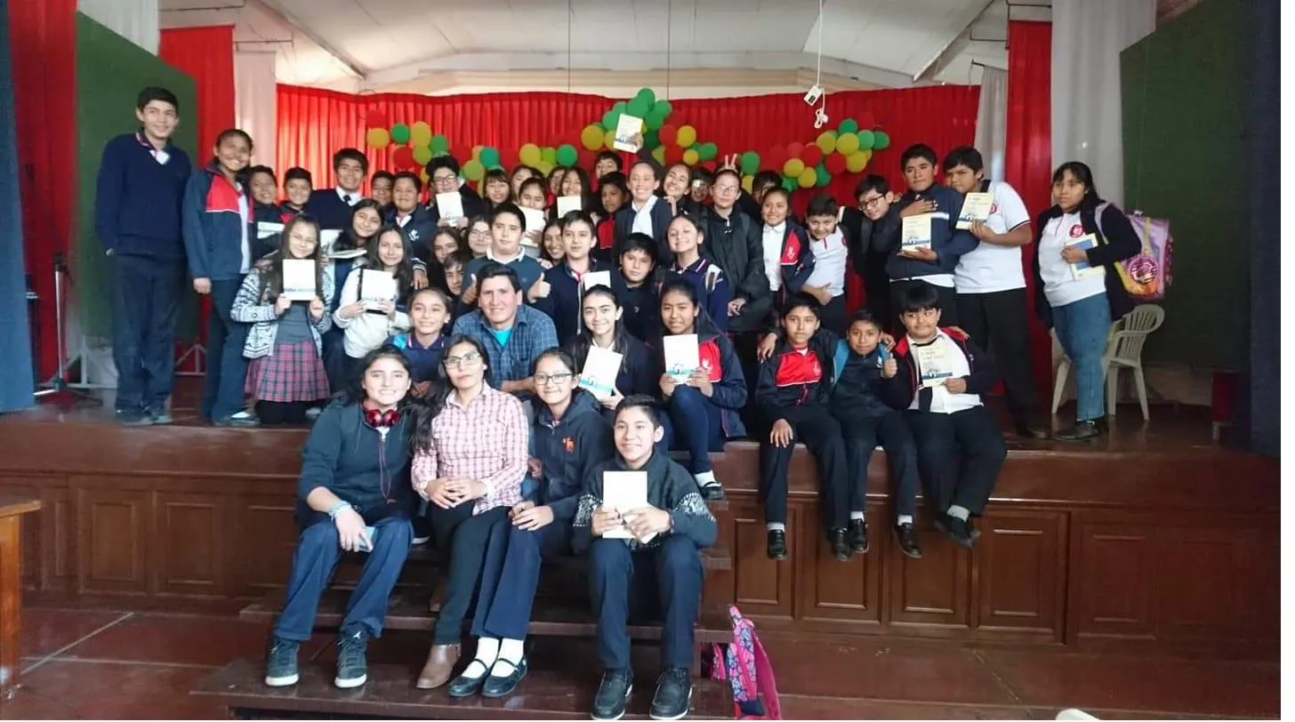 David Vildoso surrounded by children with his books at a school event